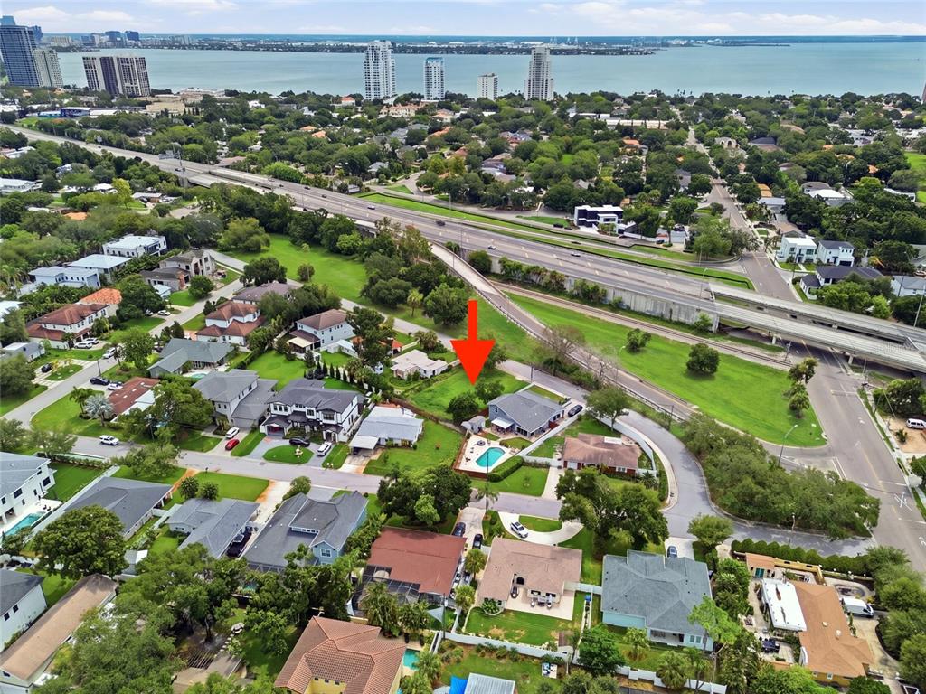 An aerial view shows a suburban house with a swimming pool near a highway overpass — 3615 S CONCORDIA AVENUE, TAMPA, FL