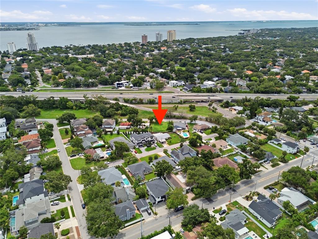 An aerial view shows a vacant residential lot marked by a red arrow in a neighborhood — 3615 S CONCORDIA AVENUE, TAMPA, FL
