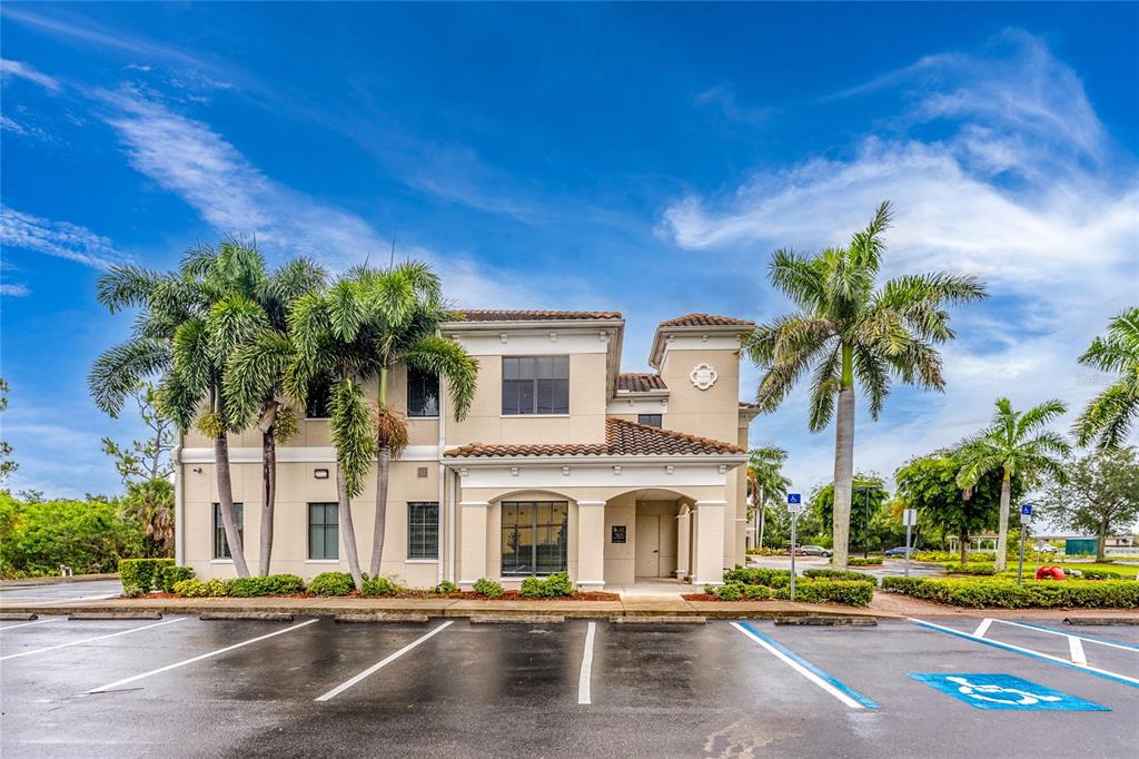 A two-story commercial building with a tiled roof and palm trees in a parking lot — 5900 and 5902 PAN AMERICAN BOULEVARD, NORTH PORT, FL