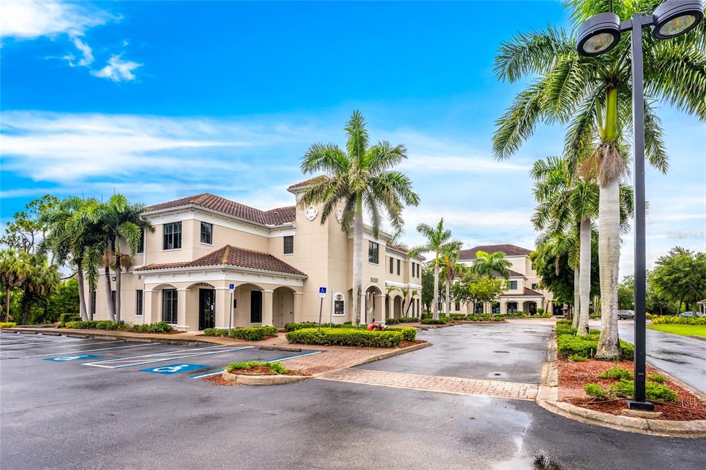 A two-story commercial building with a tile roof, palm trees, and a paved parking lot — 5900 and 5902 PAN AMERICAN BOULEVARD, NORTH PORT, FL