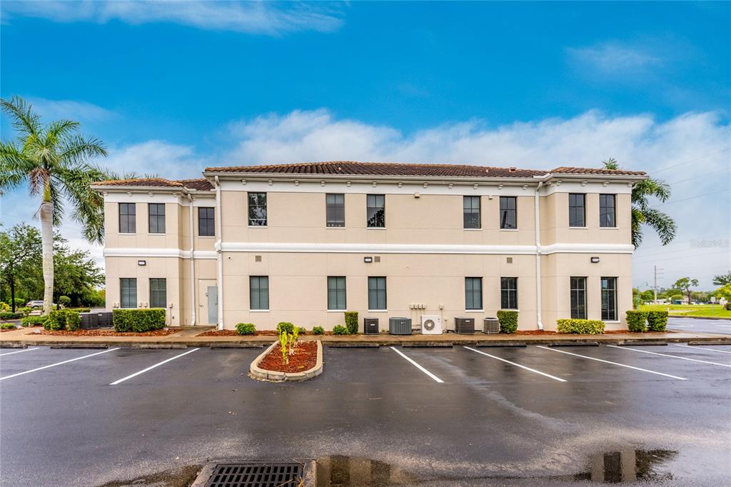 A two-story commercial building with a tan stucco exterior sits behind a paved parking lot — 5900 and 5902 PAN AMERICAN BOULEVARD, NORTH PORT, FL