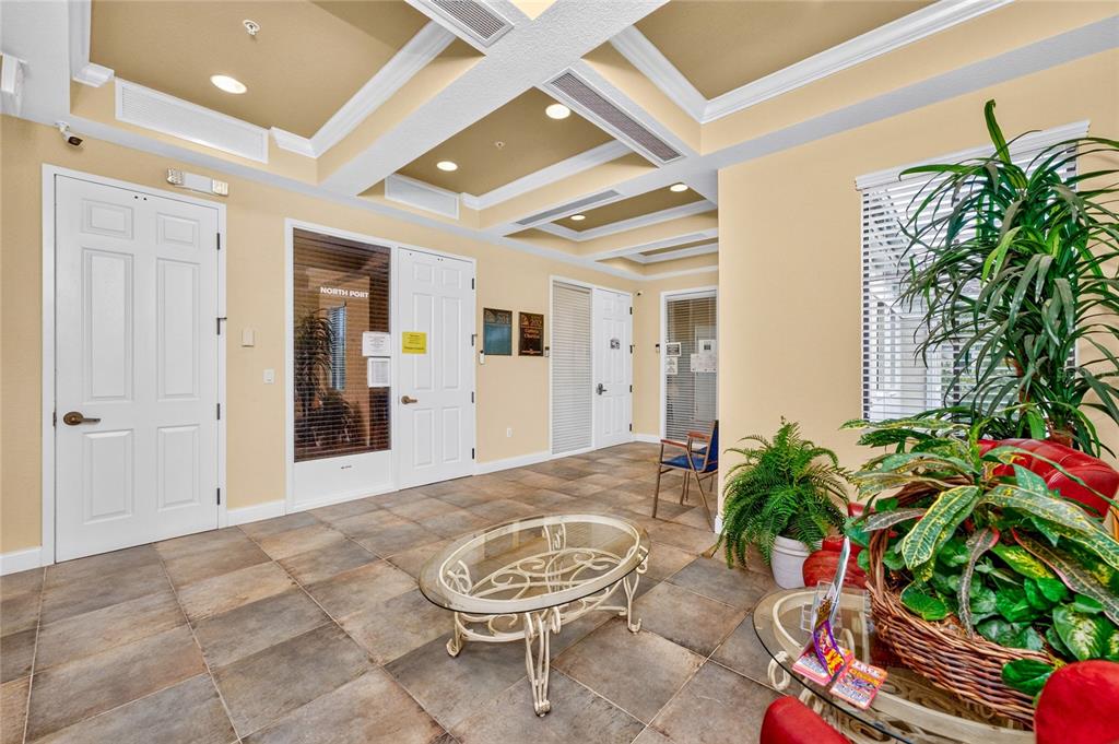 A lobby area features tile flooring, a glass coffee table, and several potted indoor plants — 5900 and 5902 PAN AMERICAN BOULEVARD, NORTH PORT, FL
