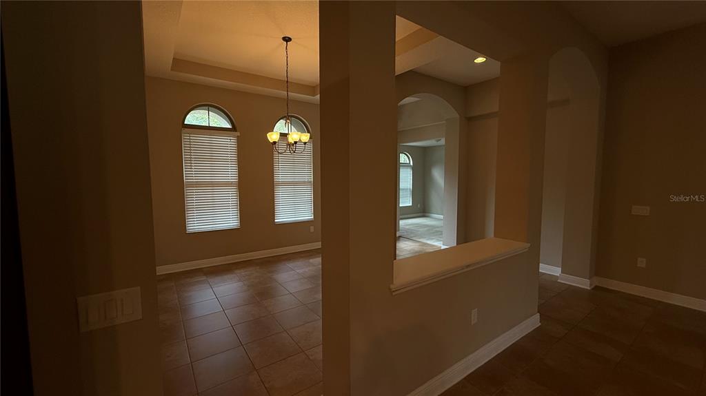 An interior view shows a dining area with arched windows and tile flooring — 109 VERDE WAY, DEBARY, FL