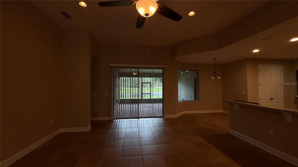 A living room with tile flooring, a ceiling fan, and a sliding glass door — 109 VERDE WAY, DEBARY, FL