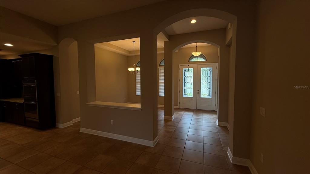An interior view shows a tiled foyer leading to a double front door with arched windows — 109 VERDE WAY, DEBARY, FL