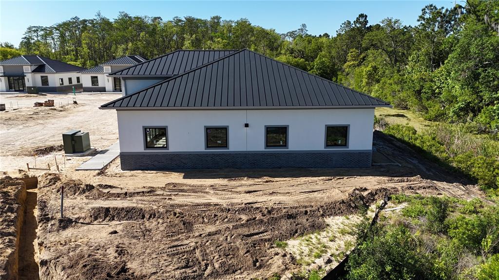 An exterior view of a newly constructed building with a metal roof and brick base — 50 EXCHANGE LOOP LOOP UNIT 5, PALM COAST, FL