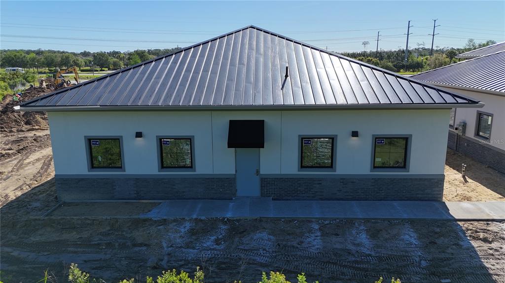 An exterior view of a single-story building with a metal roof and brick base — 50 EXCHANGE LOOP LOOP UNIT 5, PALM COAST, FL