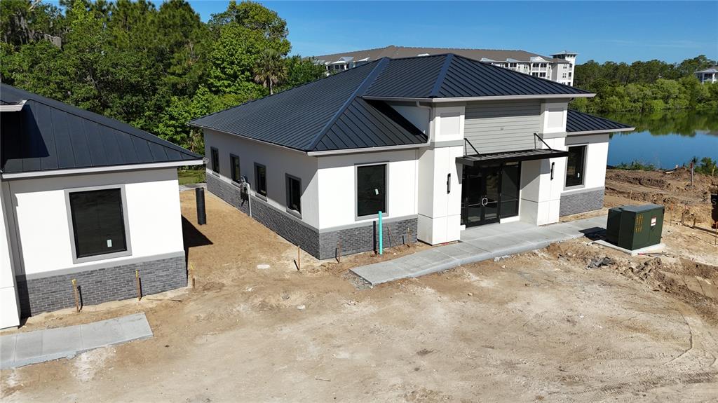 An exterior view of a modern single-story building with a dark metal roof and brick base — 50 EXCHANGE LOOP LOOP UNIT 5, PALM COAST, FL