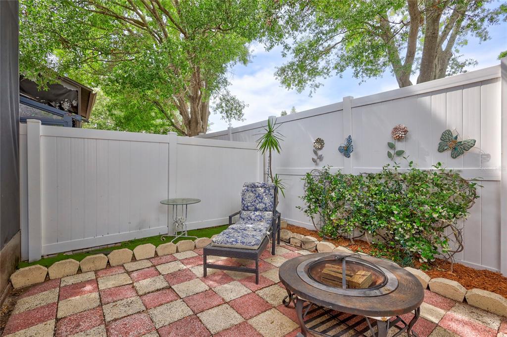 A patio features a checkered tile floor, a lounge chair, and a metal fire pit — 2811 S PINES DRIVE UNIT 15, LARGO, FL
