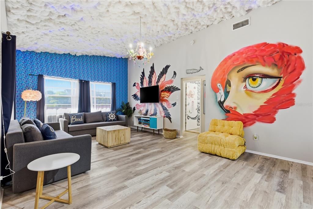 A living room features a cloud-textured ceiling, a large mural, and blue patterned wallpaper — 527 BEACH ROAD, SARASOTA, FL