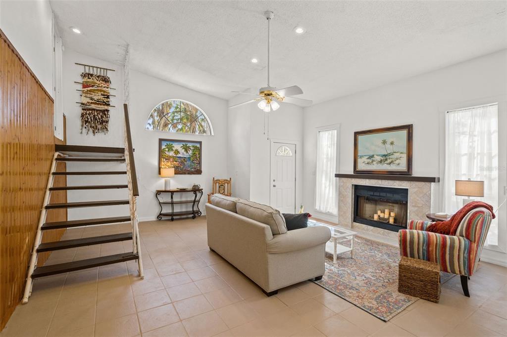 A living room features a fireplace, a staircase, tile flooring, and a ceiling fan — 1524 INDIAN BAY ROAD, HERNANDO BEACH, FL