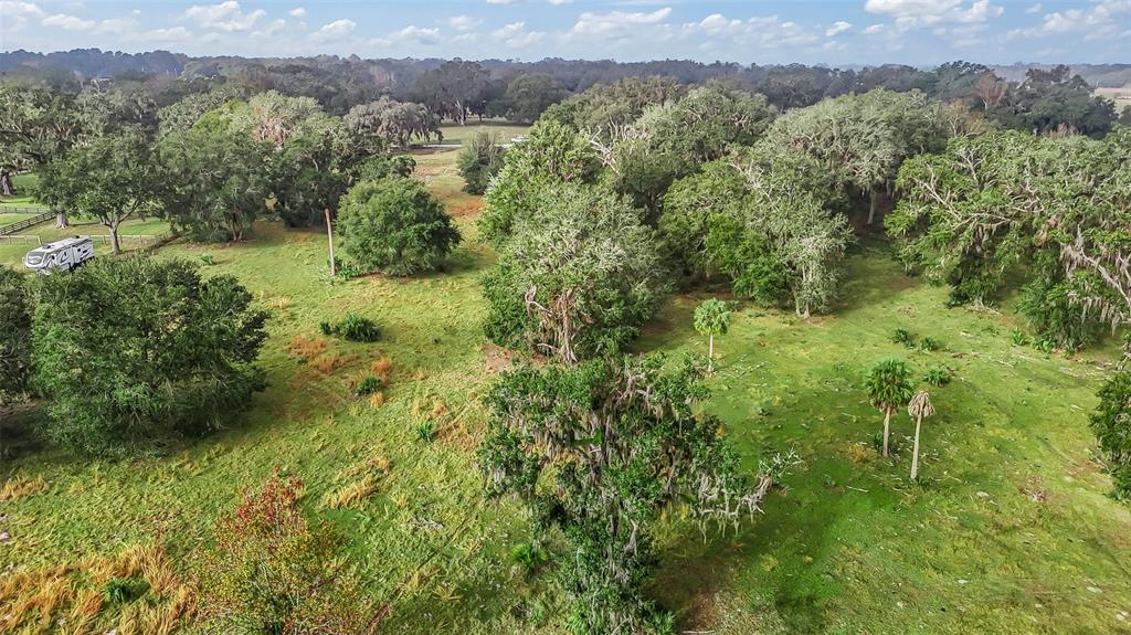 An aerial view of a grassy, tree-filled lot with a parked recreational vehicle — TRACT 3 - CR 221, WILDWOOD, FL