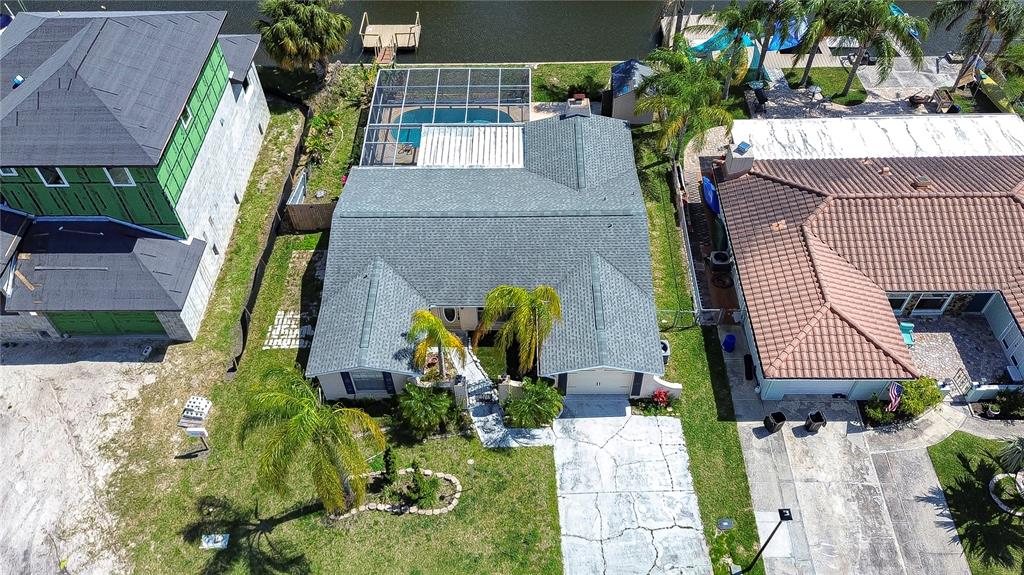 An aerial view of a residential house with a pool, screened lanai, and waterfront dock — 9826 ISLAND HARBOR DRIVE, PORT RICHEY, FL