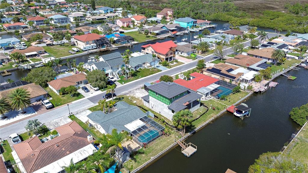 An aerial view shows waterfront houses with pools and docks along a canal — 9826 ISLAND HARBOR DRIVE, PORT RICHEY, FL