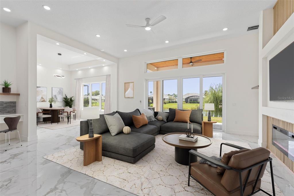 A modern living room features a dark sectional sofa, marble floors, and large glass doors — 116 LONGVIEW WAY N, PALM COAST, FL
