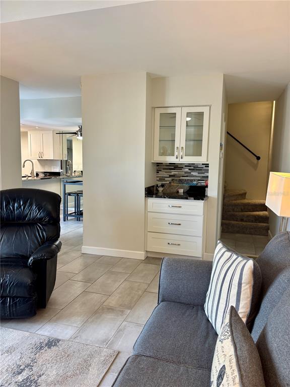 A living area features a built-in wet bar with white cabinets and a tiled backsplash — 179 MEDALLION BOULEVARD UNIT E, MADEIRA BEACH, FL