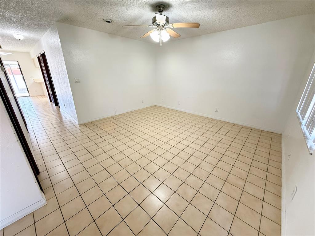 An empty room with white walls, a ceiling fan, and light-colored square floor tiles — 8336 JACKSON SPRINGS ROAD, TAMPA, FL
