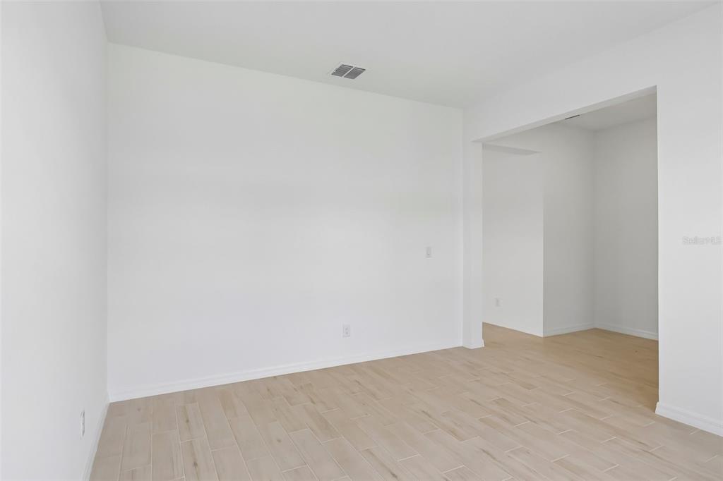 An empty room with white walls and light-colored wood-look tile flooring — 2627 CAVANAUGH DRIVE, ORLANDO, FL