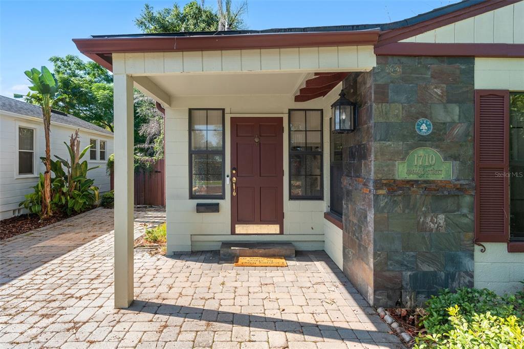 A single-story house with a brick driveway and a front porch sits behind a sidewalk — 1710 OREGON STREET, ORLANDO, FL