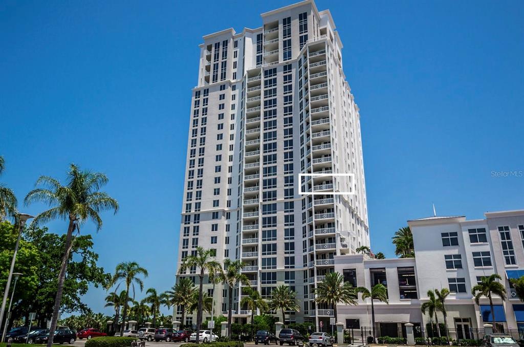 A tall, white high-rise residential building stands against a clear blue sky — 331 CLEVELAND STREET UNIT 1101, CLEARWATER, FL