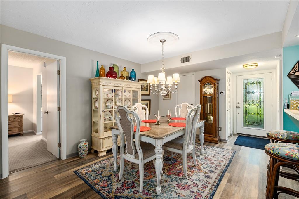 A dining room features a wooden table, chairs, a china cabinet, and a grandfather clock — 1701 PELICAN COVE ROAD UNIT GL359, SARASOTA, FL