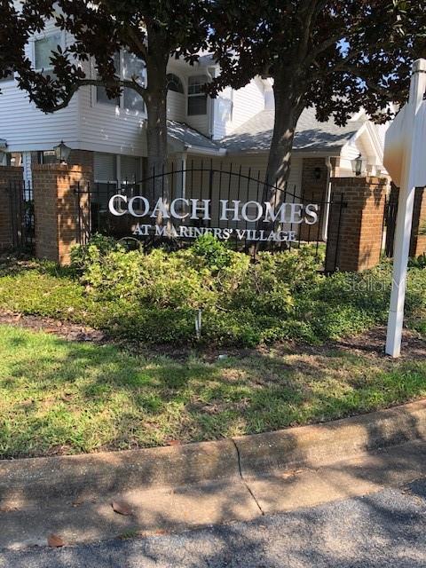 A sign for Coach Homes at Mariners' Village stands in front of a residential building — 2246 COACH HOUSE BOULEVARD UNIT 501, ORLANDO, FL
