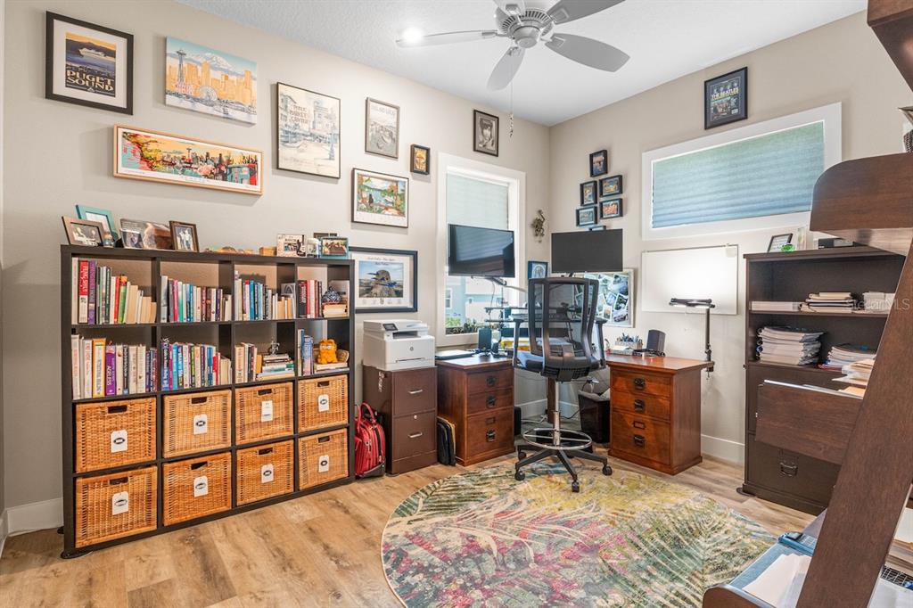 A home office features a large bookshelf, a desk with a computer, and a round rug — 1148 BAHIA HONDA KEY DRIVE, LADY LAKE, FL