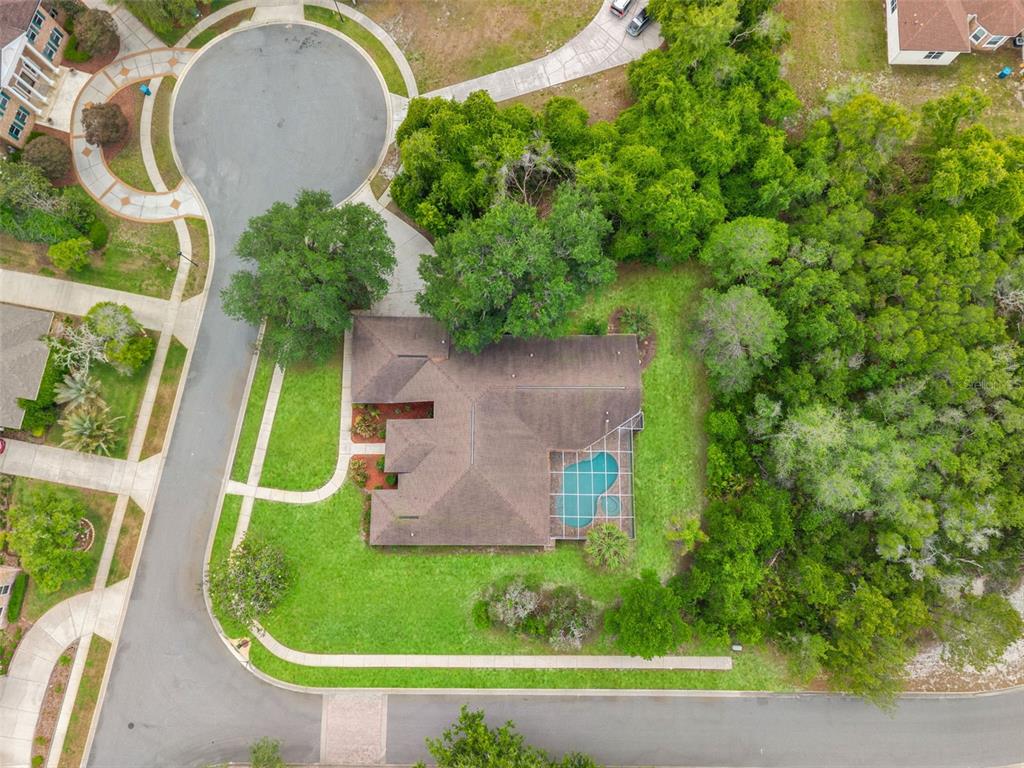 An aerial view shows a house with a screened pool situated on a corner lot — 6153 NEW OSPREY POINT, SPRING HILL, FL