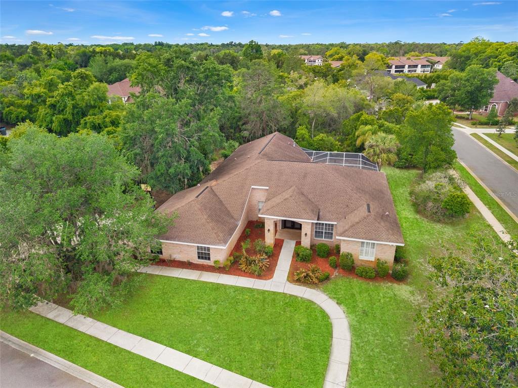 An aerial view of a single-story brick house with a brown roof and pool enclosure — 6153 NEW OSPREY POINT, SPRING HILL, FL