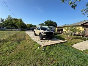 A tan pickup truck is parked on a concrete driveway in front of a house — 1221 PERKINS ROAD, ORLANDO, FL