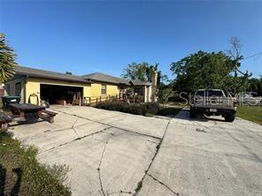 A yellow house with a garage and a pickup truck parked on a concrete driveway — 1221 PERKINS ROAD, ORLANDO, FL