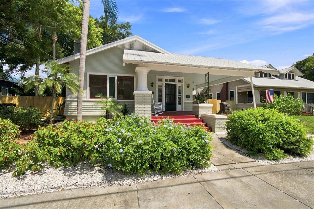 A light green bungalow with a metal roof, front porch, and red steps — 2911 N CENTRAL AVENUE, TAMPA, FL