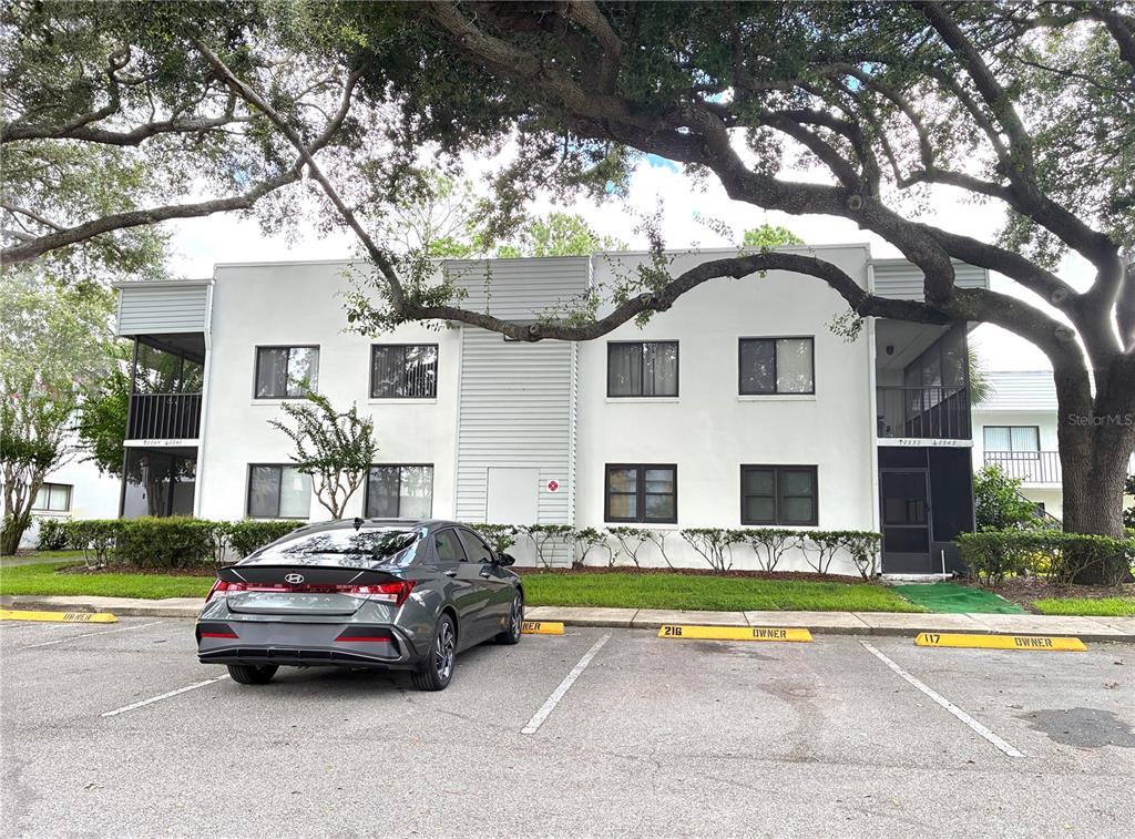 A room with tiled floors, a ceiling fan, and a wall covered in mirrored tiles — 2545 OAK PARK WAY UNIT 118, ORLANDO, FL