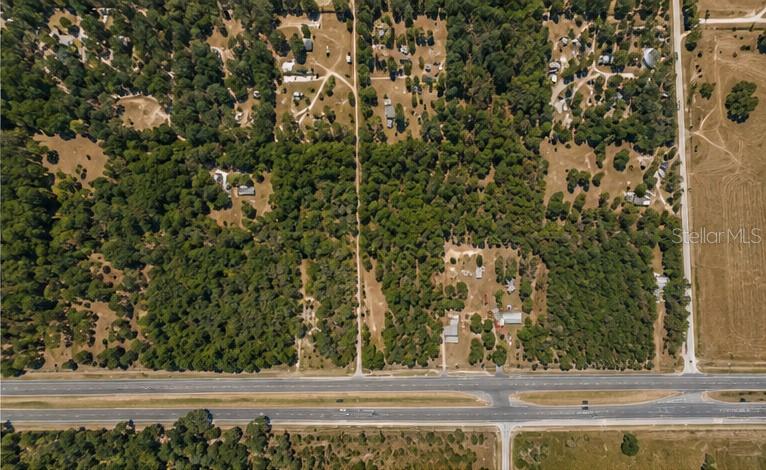 An aerial view shows a wooded residential area adjacent to a multi-lane highway — 29373 CORTEZ BOULEVARD, BROOKSVILLE, FL