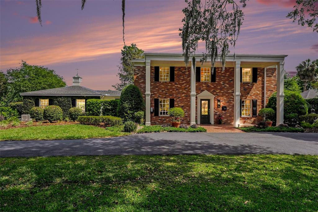A brick house exterior features a front porch with white columns and a dark door — 37403 CHURCH AVENUE, DADE CITY, FL