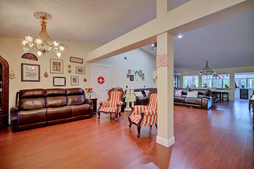 A living room with wood flooring, a brown leather sofa, and two striped armchairs — 2478 THACKER TRAIL, KISSIMMEE, FL