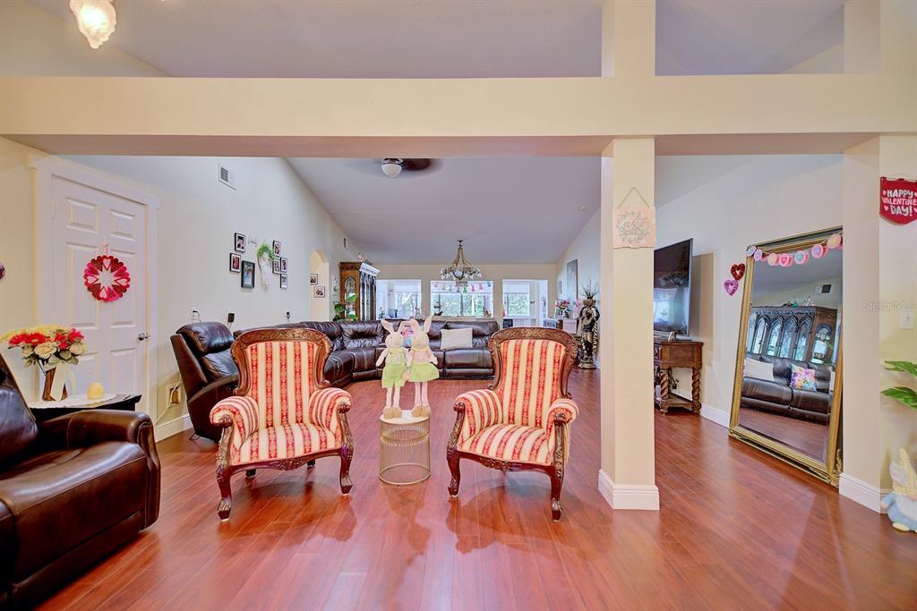 A living room features hardwood floors, two striped armchairs, and a large sectional sofa — 2478 THACKER TRAIL, KISSIMMEE, FL