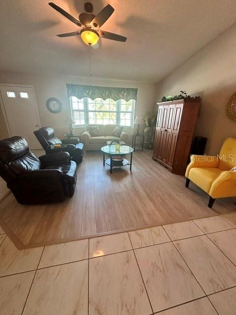 A living room features light wood-look flooring, a ceiling fan, and a yellow armchair — 4310 VANTAGE CIRCLE, SEBRING, FL