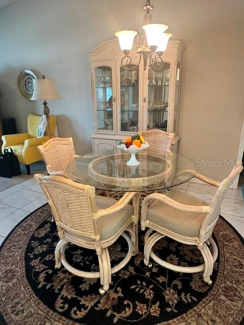 A dining room features a glass-topped rattan table with four chairs and a matching hutch — 4310 VANTAGE CIRCLE, SEBRING, FL