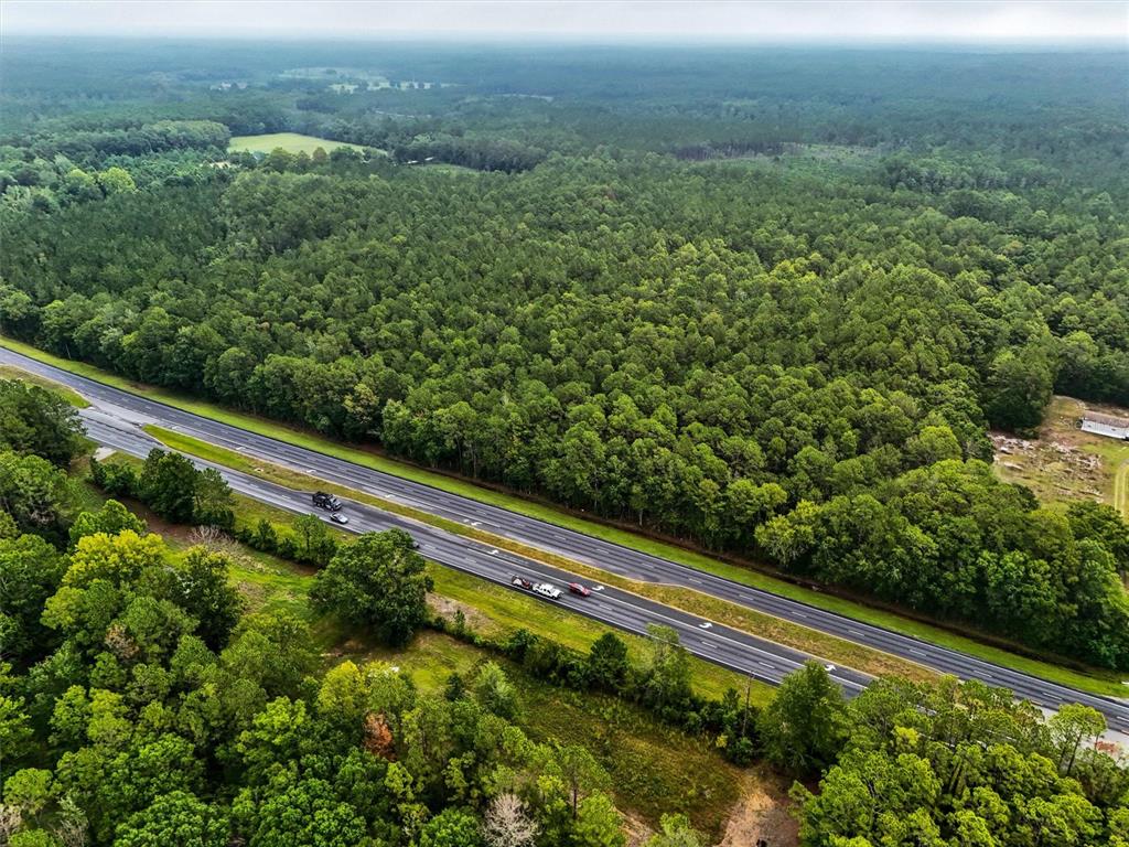 An aerial view shows a multi-lane highway cutting through a dense, green forest — TBD NE NE 6TH AVENUE, LAWTEY, FL