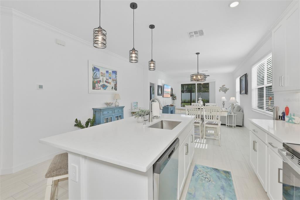 An aerial view shows a community swimming pool, clubhouse, and patio area near a lake — 12593 LILY QUARTZ LOOP, PARRISH, FL