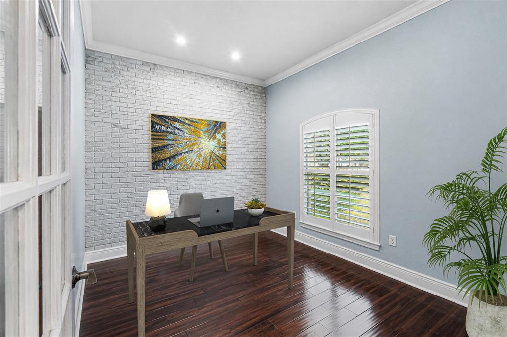 A home office features a white brick accent wall, dark wood floors, and a desk — 11916 SUMMER SPRINGS DRIVE, RIVERVIEW, FL