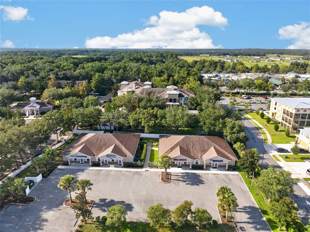 An aerial view shows two commercial buildings with parking lots surrounded by trees and landscaping — 840 & 842 HIGHWAY 466, LADY LAKE, FL
