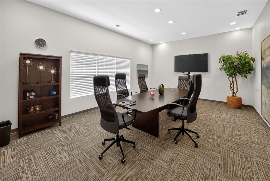 A conference room features a dark wood table, four mesh chairs, and patterned carpet flooring — 840 & 842 HIGHWAY 466, LADY LAKE, FL