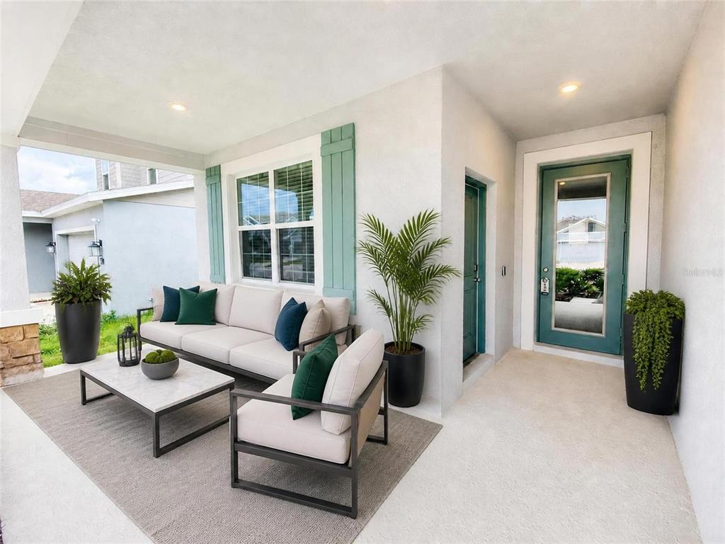 A covered front porch features a seating area with a sofa, armchair, and coffee table — 836 TIMBERLAND DRIVE, EAGLE LAKE, FL