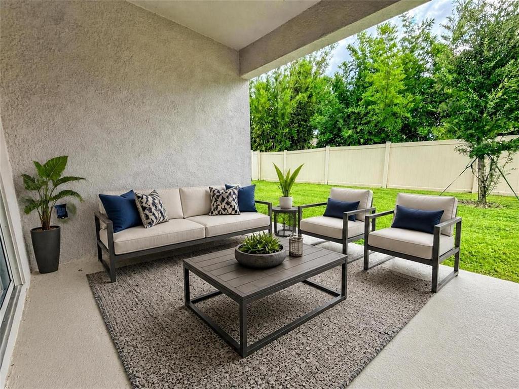 A covered patio features a modern outdoor sofa, two chairs, and a coffee table — 836 TIMBERLAND DRIVE, EAGLE LAKE, FL