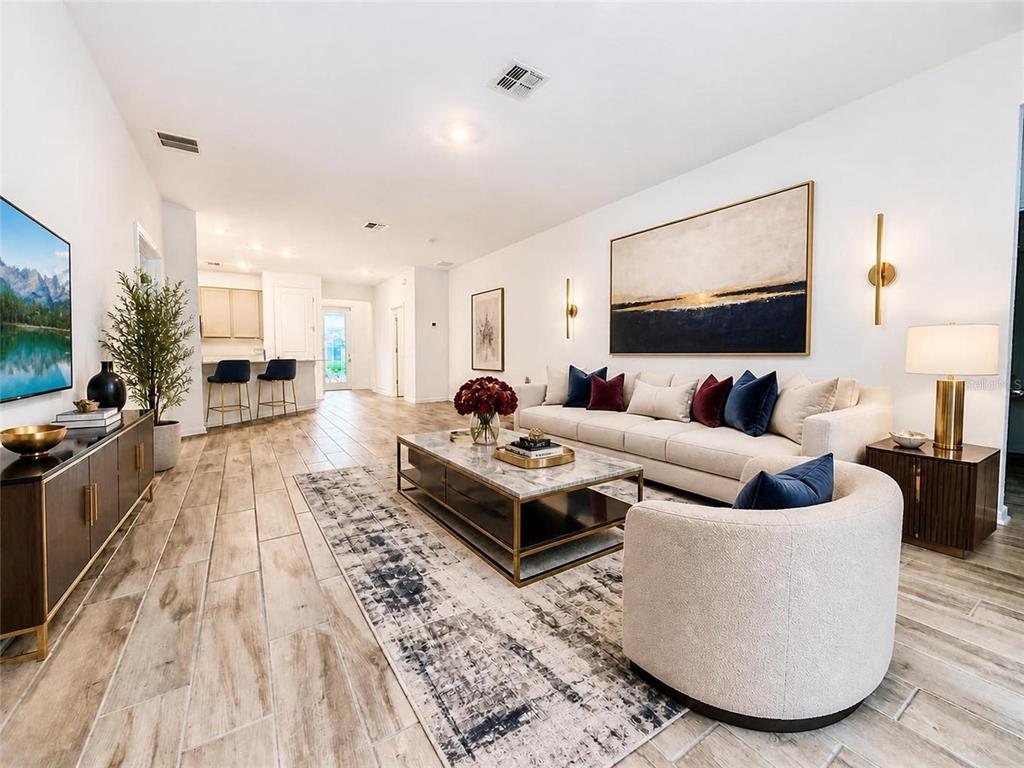 A modern living room features a white sofa, marble coffee table, and wood-look tile flooring — 836 TIMBERLAND DRIVE, EAGLE LAKE, FL