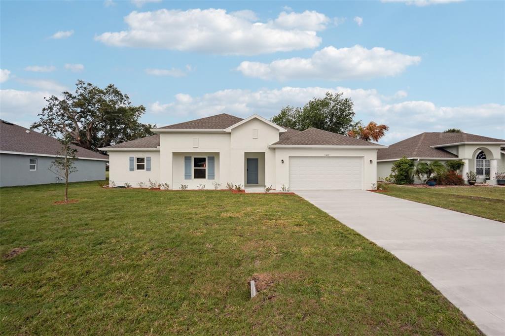 A single-story white house with a two-car garage and a concrete driveway — 16382 KINGBIRD ROAD, WEEKI WACHEE, FL
