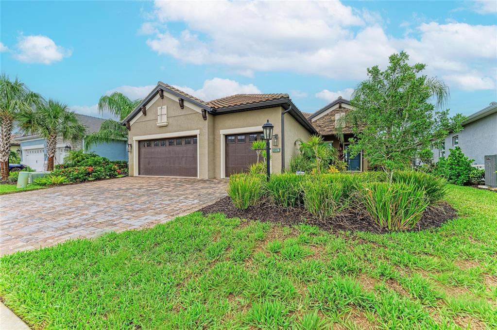 A single-story house with a paved driveway, two garage doors, and a landscaped front yard — 10913 TREVINO STREET, ENGLEWOOD, FL