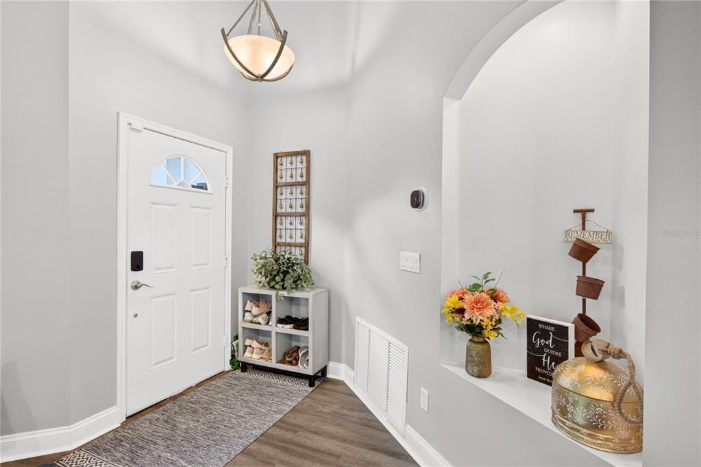 A blue front door with a decorative metal windmill and key wall art — 4339 NORTHERN DANCER WAY, ORLANDO, FL